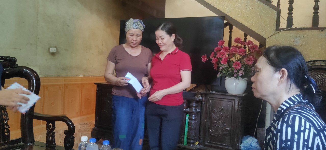 Chủ tịch Hội Nông dân thị trấn Nước tặng quà động viên hội viên Hoàng Thị Vân bị mắc bệnh hiểm nghèo