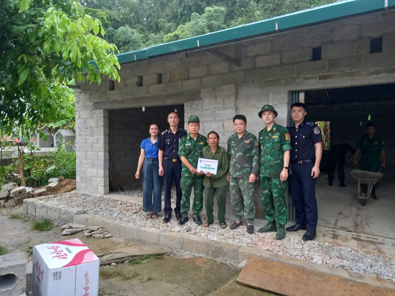 Đồng chí Trung tá Phùng Danh Tuyên, Bí thư Đảng uỷ, Chính trị viên Đồn Biên phòng Cửa khẩu quốc tế Tà Lùng - đứng thứ ba từ trái sang, và đại diện lãnh đạo Đảng uỷ xã Cách Linh cùng chụp ảnh trao tiền hỗ trợ cho ông Hoàng Văn Nhũng